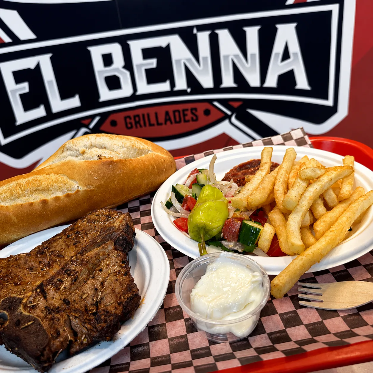 Plateau El Benna : côtelette grillée, baguette, frites, salade et sauce maison devant le logo du restaurant
